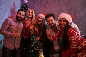 Young people with glasses of champagne at Christmas party photo