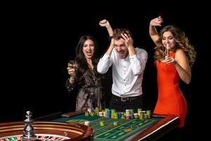 Group of young people looking excited at spinning roulette photo