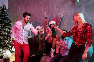 Young people with glasses of champagne at Christmas party photo