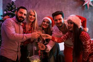 joven personas con lentes de champán a Navidad fiesta foto