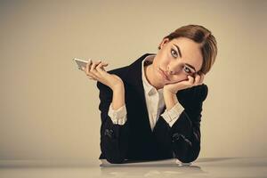 attractive dark-haired woman dressed in a black suit is sitting photo