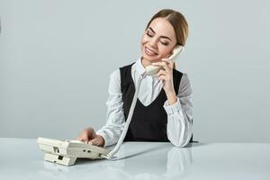 portrait of young secretary answering telephone photo