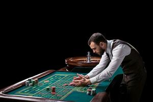 Croupier behind gambling table in a casino. photo