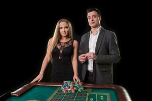 elegante Pareja a el casino apuesta en el ruleta, en un negro antecedentes foto