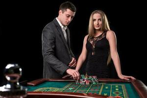 elegante Pareja a el casino apuesta en el ruleta, en un negro antecedentes foto