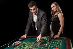 elegante Pareja a el casino apuesta en el ruleta, en un negro antecedentes foto