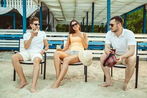 Young people enjoying summer vacation sunbathing drinking at beach bar photo