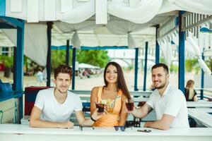 Friends toasting in summer vacation in a bar terrace on the beach photo