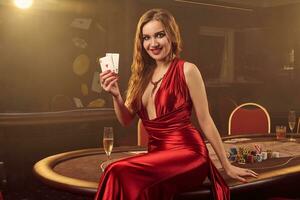 Close-up shot of a beautiful woman posing against a poker table in luxury casino. photo