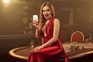 Close-up shot of a beautiful woman posing against a poker table in luxury casino. photo