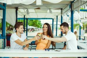 amigos tostado en verano vacaciones en un bar terraza en el playa foto