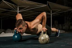 Man doing push-up exercise with dumbbell photo