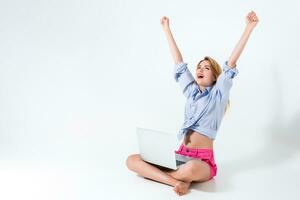 young woman sitting on the floor and using laptop photo