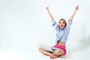 young woman sitting on the floor and using laptop photo