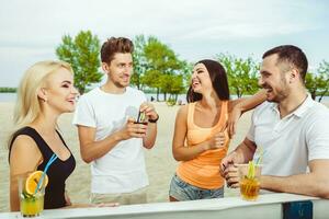 amigos teniendo divertido a el bar al aire libre, Bebiendo cocteles foto