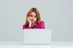 young woman sitting in the table and using laptop photo