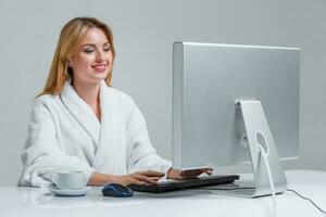 young woman sitting in the table and using computer photo