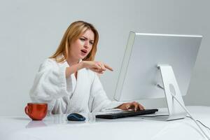 young woman sitting in the table and using computer photo