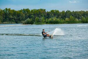 Skillful wakeboarder cutting water with edge of board creating splashes photo