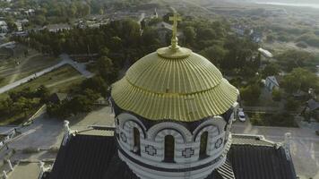 Golden domes of the Orthodox Vladimir Cathedral in Chersonesos, on the background of blue sea. Shot. The largest temple on the Crimean Peninsula. Top view of the temple of Chersonesos photo