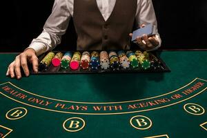 Close up of holdem dealer with playing cards and chips on green table photo