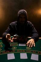 Portrait of a professional poker player sitting at poker table photo