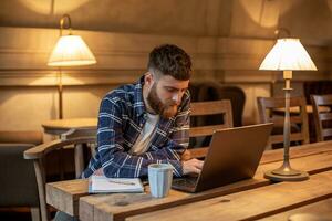 joven profesional surf el Internet en su ordenador portátil en un café foto