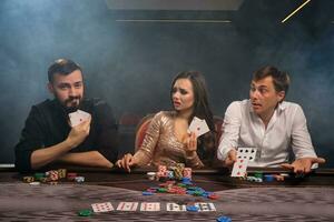 Group of a young rich friends are playing poker in casino. photo