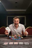 hermoso emocional hombre es jugando póker sentado a el mesa en casino. foto