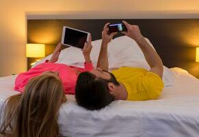 Young couple lying at their backs on the bed photo