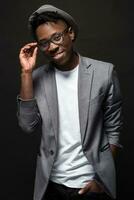 Portrait of a fashionable african american man smiling on black background photo