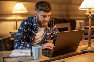 joven profesional surf el Internet en su ordenador portátil en un café foto