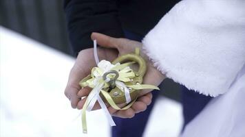 Wedding symbol, lock in hands of bride and groom. Newlyweds fix the lock on the bridge as a symbol of love. Padlock in the hands of the bride and groom. Lock in heart shape on the railing of bridge - photo