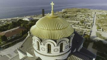 Golden domes of the Orthodox Vladimir Cathedral in Chersonesos, on the background of blue sea. Shot. The largest temple on the Crimean Peninsula. Top view of the temple of Chersonesos photo