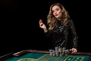 Woman playing in casino. Woman stakes piles of chips playing rou photo