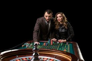 hombre con mujer jugando ruleta a el casino. adiccion a el foto