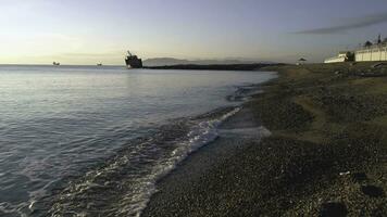 Stones on beach and sea water. Shot. Pebble beach at sunset. Beach scene with many pebbles in the dunes photo