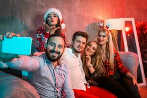 Friends making selfie while celebrating Christmas or New Year eve at home photo