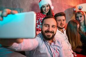 Friends making selfie while celebrating Christmas or New Year eve at home photo