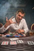 hermoso emocional hombre es jugando póker sentado a el mesa en casino. foto