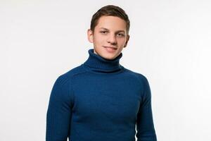 Studio shot of young man wearing blue turtleneck sweater against photo