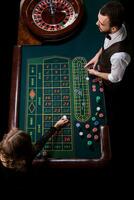 crupier y mujer jugador a un mesa en un casino. imagen de un C foto