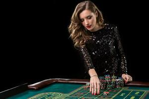 Woman playing in casino. Woman stakes piles of chips playing rou photo