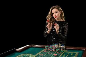 Woman playing in casino. Woman stakes piles of chips playing rou photo