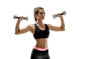 Athletic woman with dumbbells doing sport exercise, isolated on white background photo