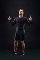masculino modelo en activo ropa de deporte en contra negro antecedentes con Copiar espacio foto