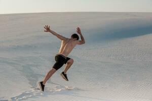 ajuste hombre corriendo rápido en el arena. poderoso corredor formación al aire libre en verano. foto