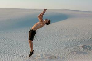 Man study parkour on their own. Acrobatics in the sand photo