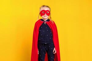 superhéroe pequeño niña en un rojo impermeable y un máscara foto
