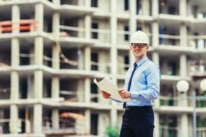 Handsom construction engineer at the construction site looking at the camera photo